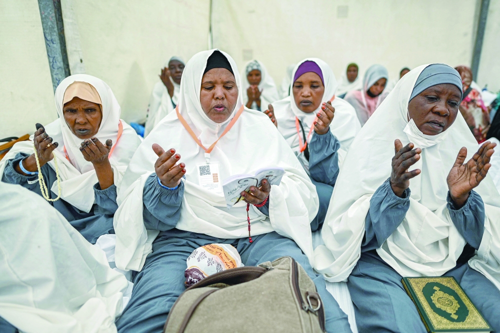 Muslim pilgrims pray upon their arrival in Mina. — AFP 