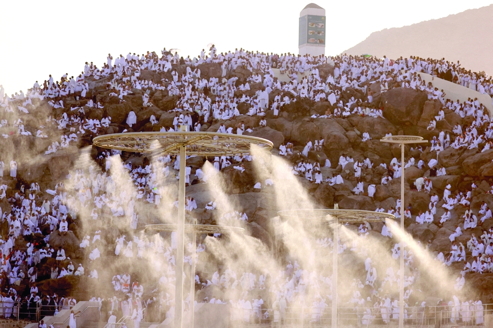 Muslim pilgrims gather on the Mount of Mercy at the plain of Arafat as water mist is sprayed due to high temperature during the annual Haj pilgrimage. — Reuters