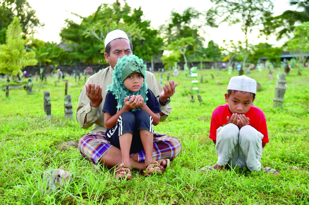Thai Muslims visit a cemetery during the Islamic Eid al Adha festival in Thailand's southern province of Narathiwat. - AFP