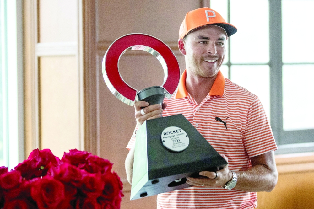July 2, 2023; Detroit, MI, USA; Rickie Fowler picks up the championship trophy after winning the Rocket Mortgage Classic at Detroit Golf Club in Detroit on Sunday, July 2, 2023. Mandatory Credit: Junfu Han-USA TODAY Sports
