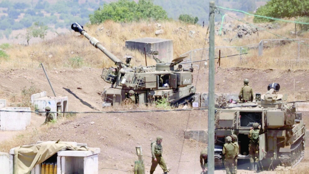  Israeli soldiers stand near army self-propelled artillery vehicles on the outskirts of Kiryat Shmona near Israel's border with Lebanon on Thursday. - AFP 