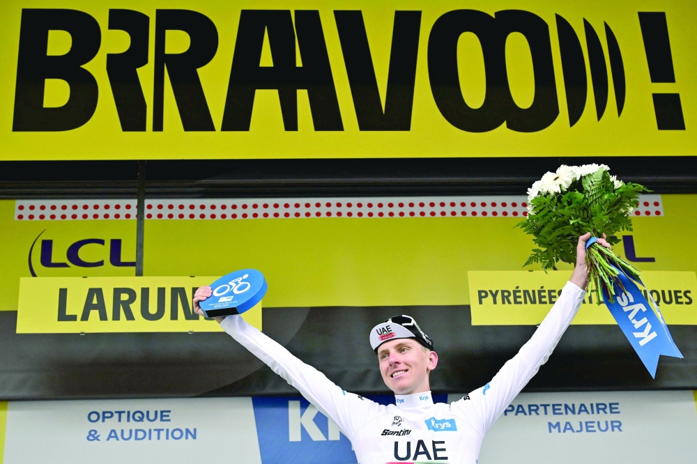 UAE Team Emirates' Slovenian rider Tadej Pogacar celebrates on the podium with the best young rider's white jersey after the 5th stage of the 110th edition of the Tour de France cycling race, 163 km between Pau and Laruns, in the Pyrenees mountains in southwestern France, on July 5, 2023. (Photo by Marco BERTORELLO / AFP)

