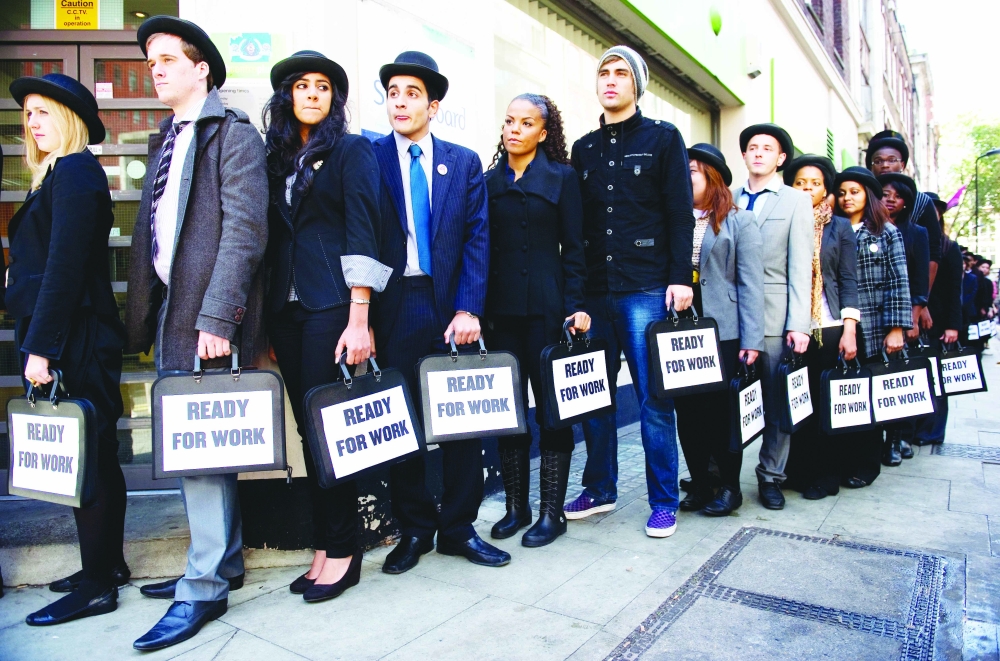  British musicians join unemployed young people as they stand in line outside a central London job centre. — AFP