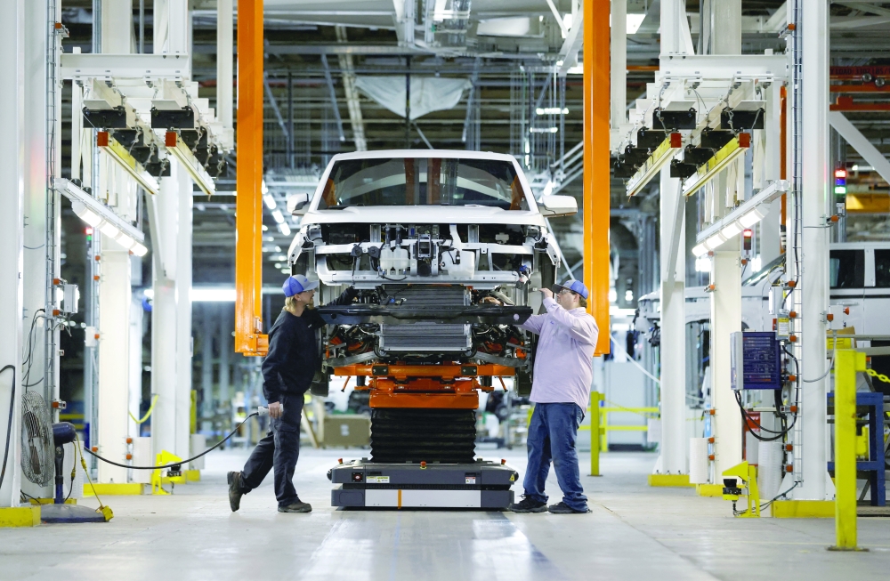 Workers tend to an unfinished electric pick-up truck on the assembly line at Foxconn's electric vehicle production facility in Lordstown, Ohio. — Reuters