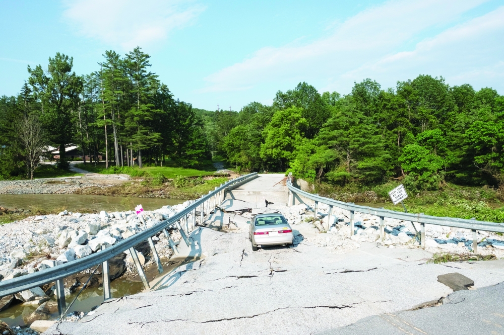 An abandoned car on a destroyed bridge just outside Ludlow, Vermont. 