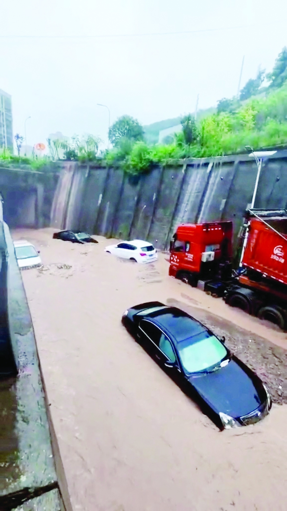 Vehicles are submerged in water due to flooding in Wanzhou district Chongqing, China, in this still image from a social media. - Reuters
 