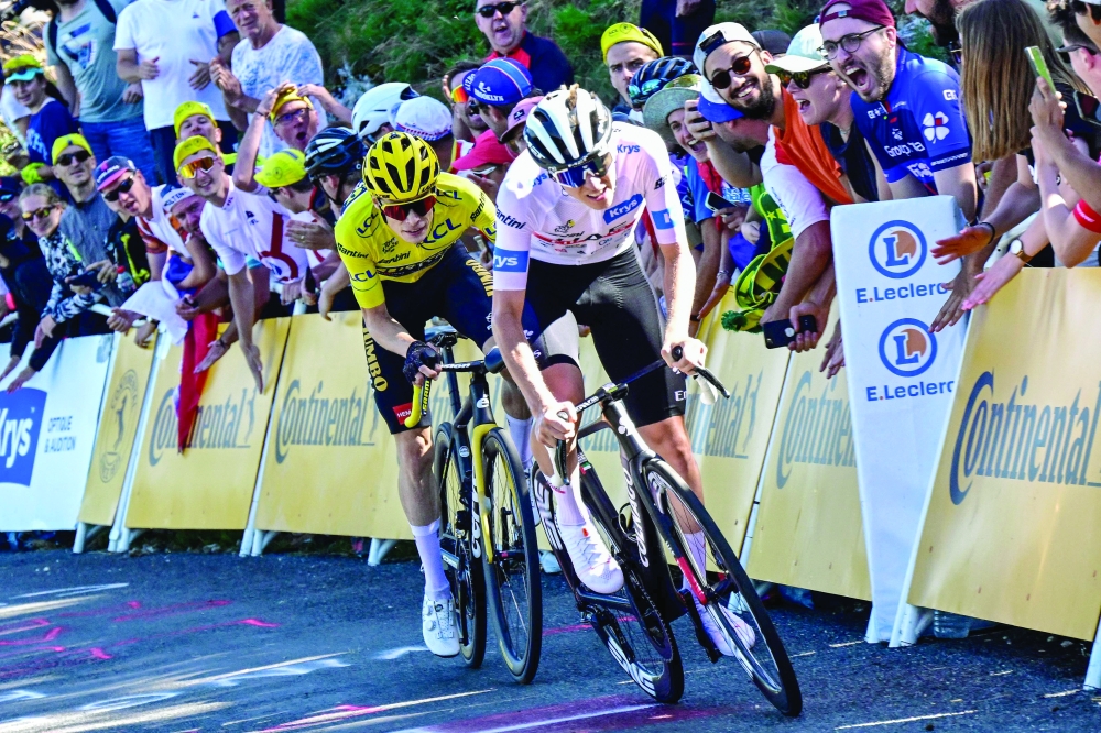 UAE Team Emirates' Slovenian rider Tadej Pogacar wearing the best young rider's white jersey cycles ahead of Jumbo-Visma's Danish rider Jonas Vingegaard wearing the overall leader's yellow jersey cycles in the final ascent of Col du Grand Combier in the final kilometres of the 13th stage of the 110th edition of the Tour de France cycling race, 138 km between Chatillon-sur-Chalaronne in central-eastern France and Grand Colombier, in the Jura mountains in Eastern France, on July 14, 2023. (Photo by Bernard PAPON / POOL / AFP)