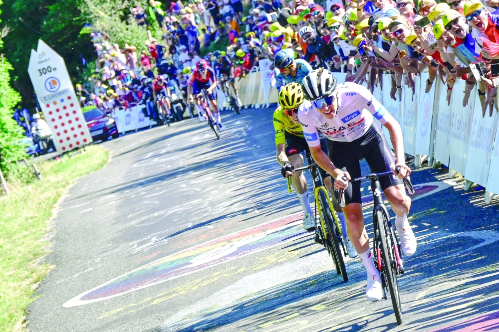 UAE Team Emirates' Slovenian rider Tadej Pogacar wearing the best young rider's white jersey cycles ahead of Jumbo-Visma's Danish rider Jonas Vingegaard wearing the overall leader's yellow jersey cycles in the final ascent of Col du Grand Combier in the final kilometers of the 13th stage of the 110th edition of the Tour de France cycling race, 138 km between Chatillon-sur-Chalaronne in central-eastern France and Grand Colombier, in the Jura mountains in Eastern France, on July 14, 2023. (Photo by Bernard PAPON / POOL / AFP)

