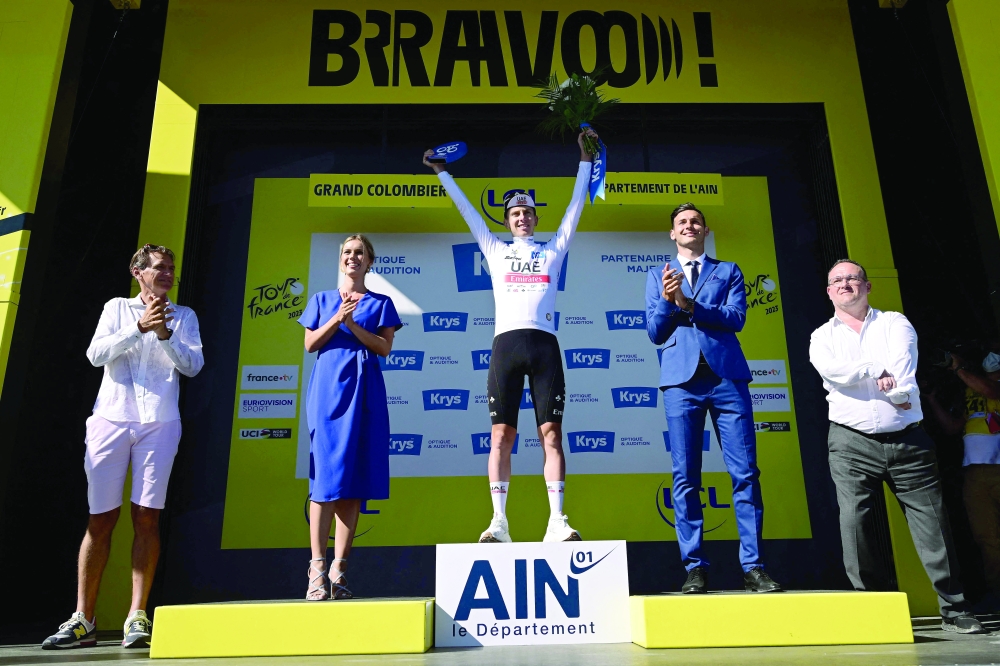 UAE Team Emirates' Slovenian rider Tadej Pogacar (C) celebrates on the podium with the best young rider's white jersey after the 13th stage of the 110th edition of the Tour de France cycling race, 138 km between Chatillon-sur-Chalaronne in central-eastern France and Grand Colombier, in the Jura mountains in Eastern France, on July 14, 2023. (Photo by Marco BERTORELLO / AFP)


