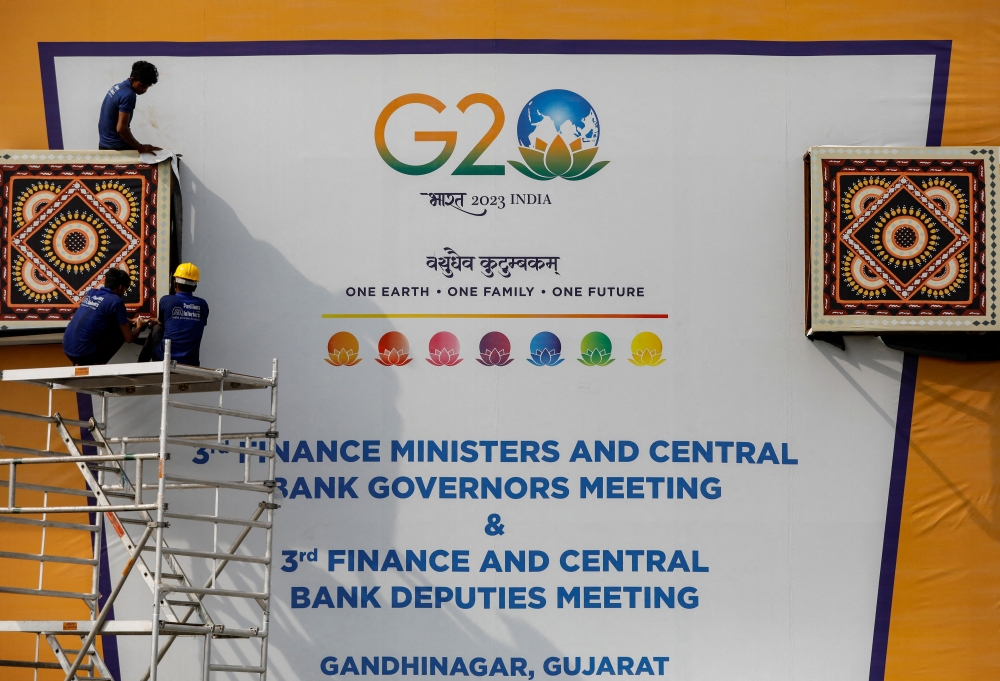 Workers work to install a hoarding board near the venue of G20 Finance Ministers and Central Bank Governors meeting at Gandhinagar in Gujarat, India July 13, 2023