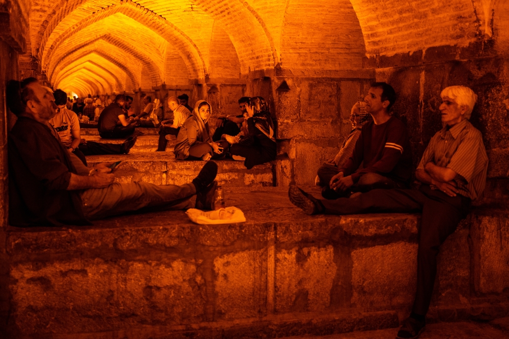 People socialize after sunset under the Khaju Bridge in Isfahan, Iran in June 2023. (The New York Times) 
