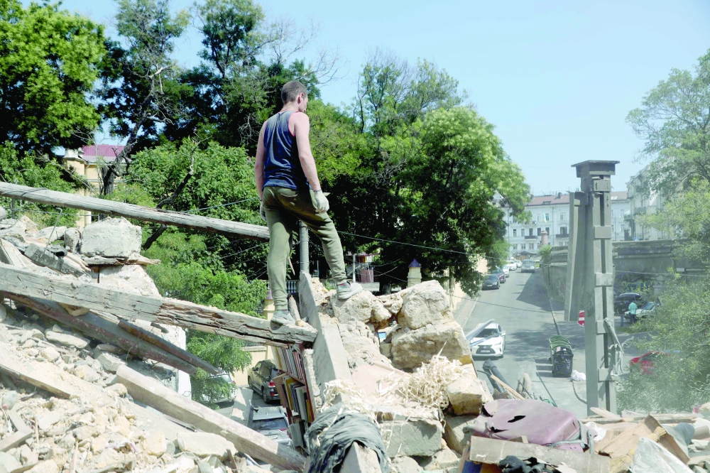 Workers clear the rubble in the centre of Odesa after a Russian military strike. — AFP