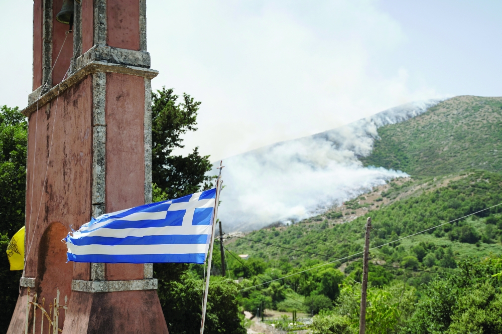 Smoke rises as wildfire burns near the village of Palia Perithia, on the island of Corfu, Greece. — Reuters
