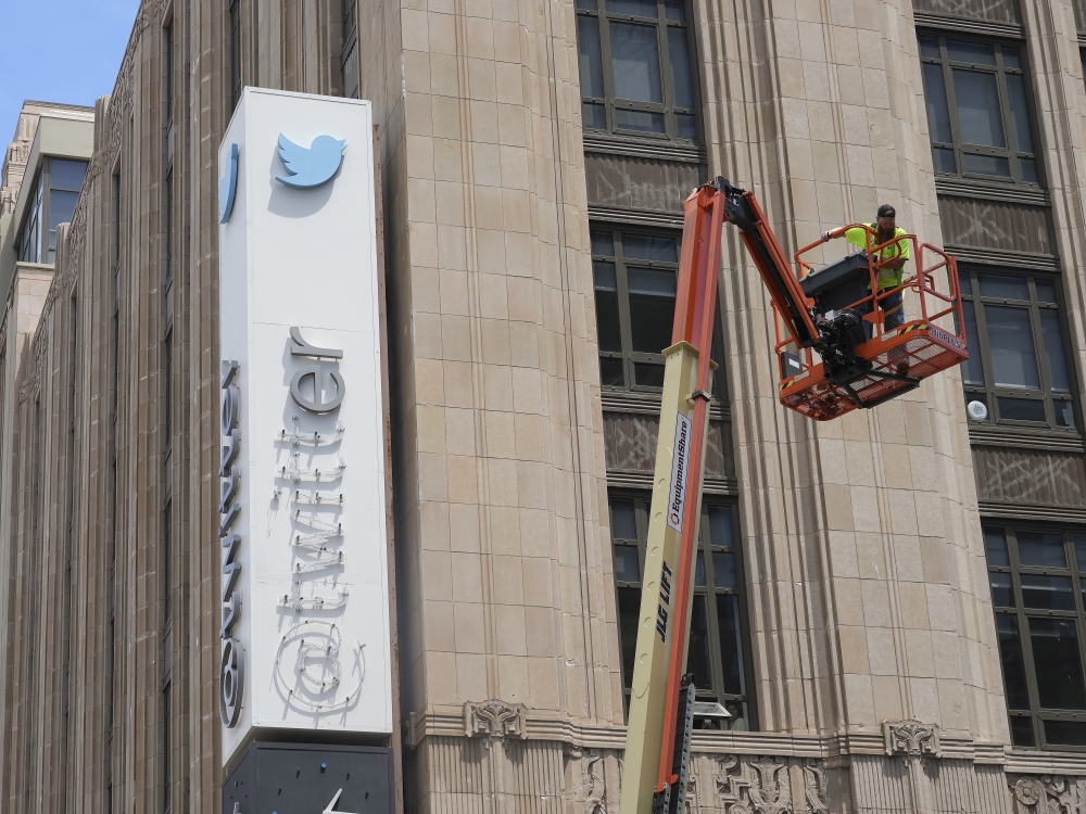 A contractor stops work to remove letters from the Twitter sign at the company's headquarters in San Francisco, July 24, 2023. (Jim Wilson/The New York Times)