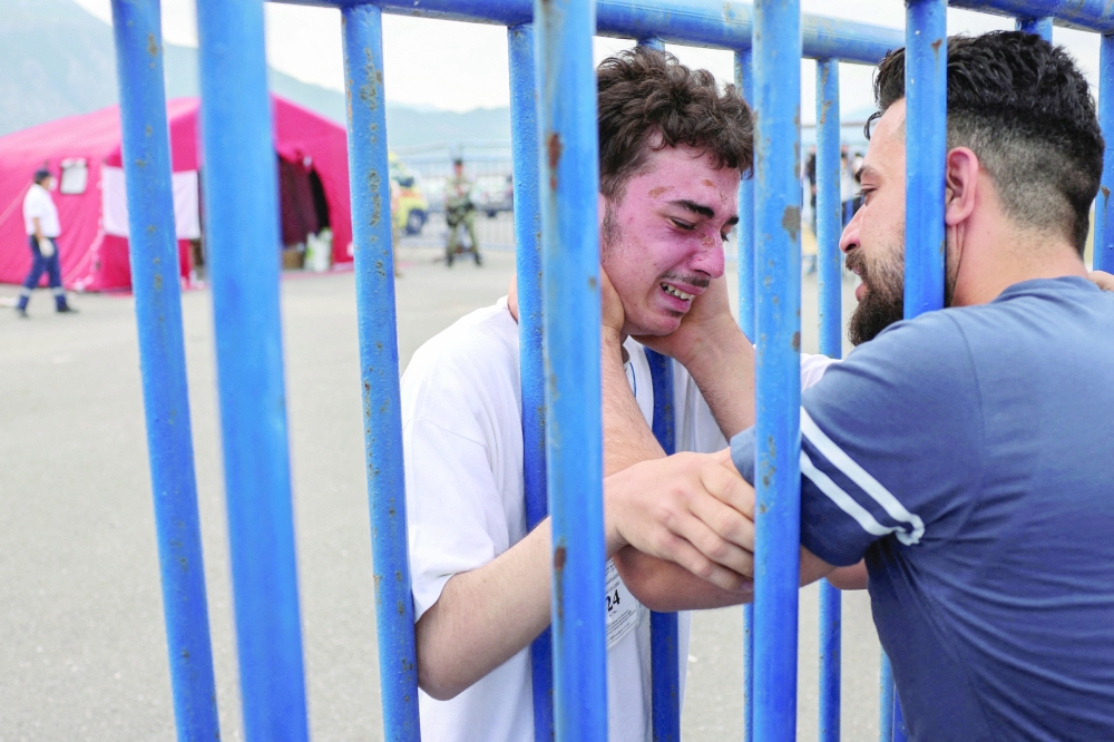 Brothers reunite after deadly shipwreck at open sea off Greece after their boat capsized, at the port of Kalamata, Greece. — Reuters file photo 
