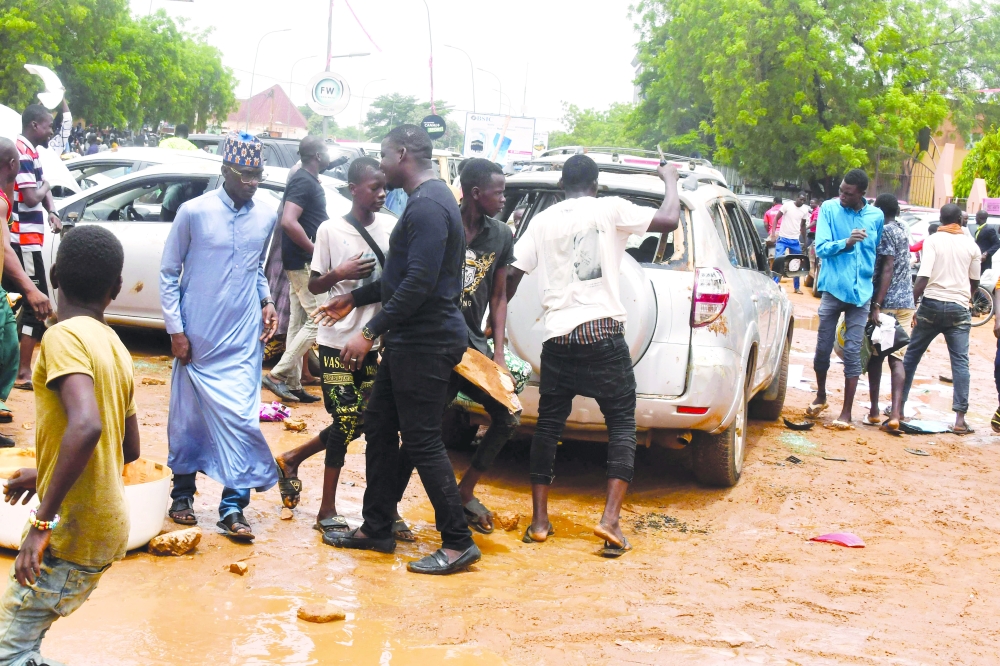 Supporters of the Nigerien defence and security forces are seen next to a vehicle with smashed windows at the headquarters of the Nigerien Party for Democracy and Socialism (PNDS), the party of overthrown President Mohammed Bazoum in Niamey. - AFP