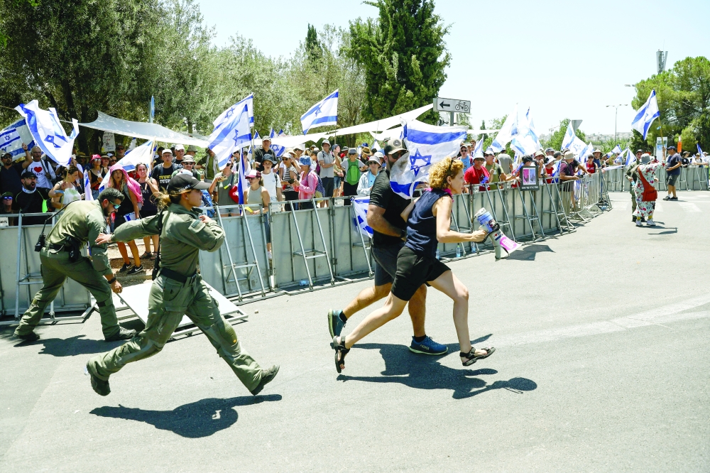 Protesters run after crossing the police line at the entrance to the Knesset during a demonstration against Israeli PM Benjamin Netanyahu and government's judicial overhaul, in Jerusalem. — Reuters 