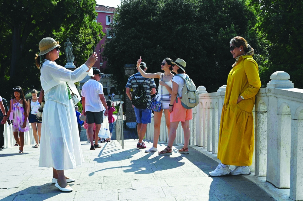 Tourists taking photos on the Tolentini bridge in Venice. — AFP 