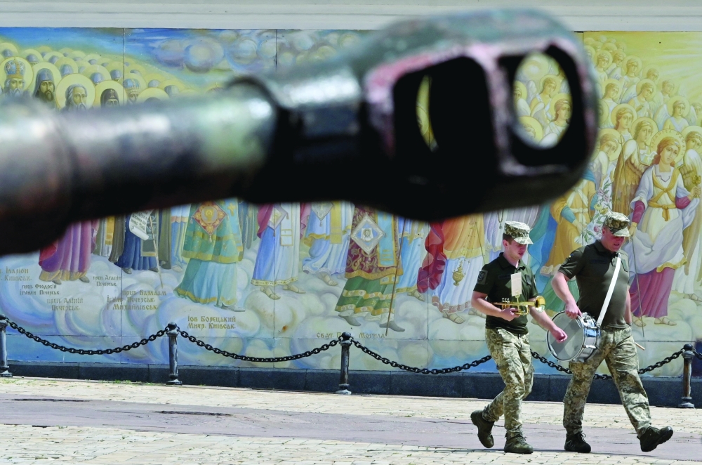 Ukrainian servicemen walk past a tank during an open-air exhibition of destroyed Russian military vehicles at Mykhaylo Square in Kyiv, on Thursday. - AFP