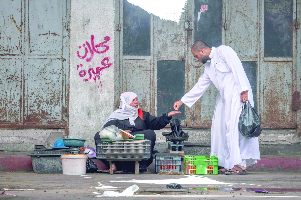 A Palestinian woman sells fresh produce on a street in Gaza on Friday. — AFP