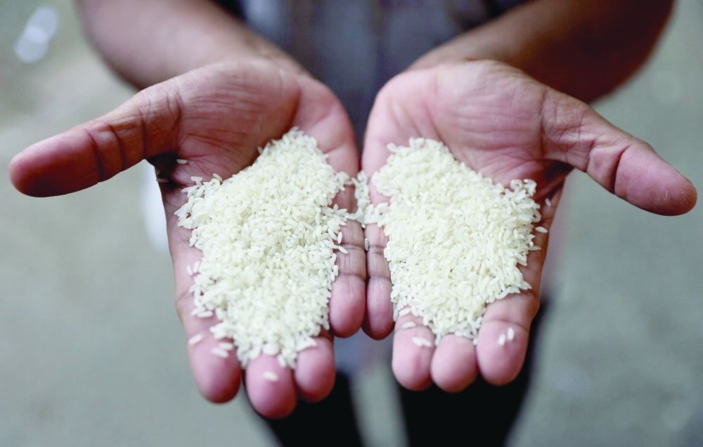 A man compares different grains of rice at a wholesale market in Navi Mumbai, India, on Friday. — Reuters