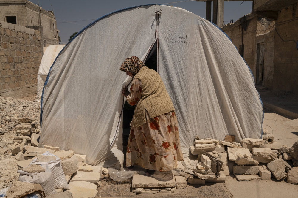 Fatima al Miree, 61, closes the tent where she sleeps at night in Jinderes, Syria, on Aug. 8, 2023. (Nicole Tung/The New York Times)