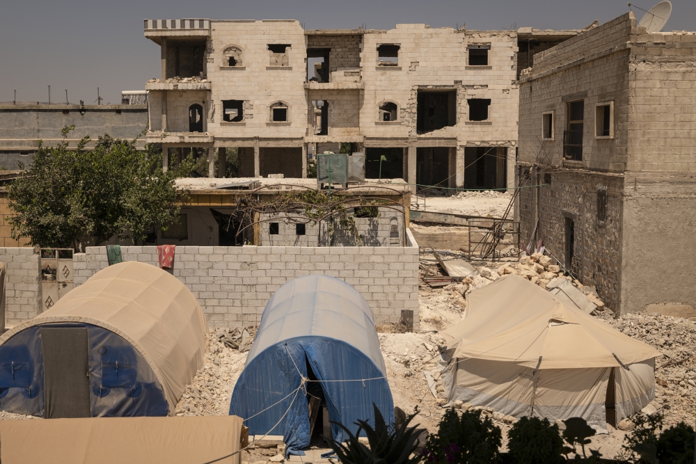 Tents stood outside damaged homes in Jindires, Syria, on Aug. 8, 2023. (Nicole Tung/The New York Times)