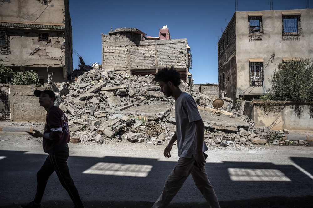 Local residents walk through the rubble of a residential neighborhood in the village of Amizmiz, Morocco, on Sunday, Sept. 10, 2023. (Sergey Ponomarev/The New York Times)