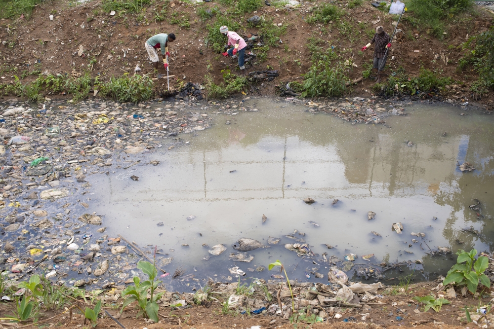 Workers remove plastic litter from a canal flowing into Maragondanahalli Lake, in Bengaluru, India, July 28, 2023. (Priyadarshini Ravichandran/The New York Times)