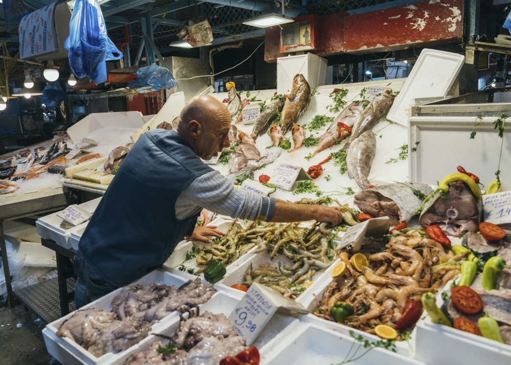 A fish vendor at the central market in Athens, on Sept. 9, 2023. (Marco Arguello/The New York Times)