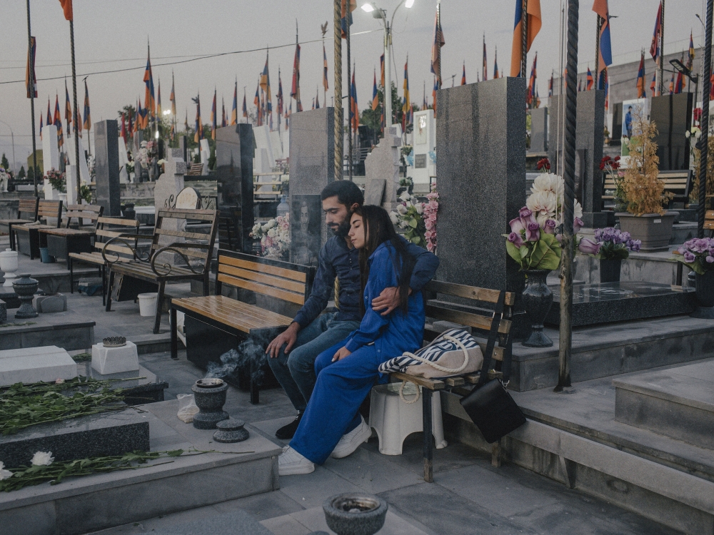 A couple at the grave of a family member who was killed in fighting in 2020, when a rebuilt Azerbaijani military crushed Armenian forces, at the Yerablur Military Memorial Cemetery in the Armenian capital of Yerevan, Sept. 28, 2023. (Nanna Heitmann/The New York Times)