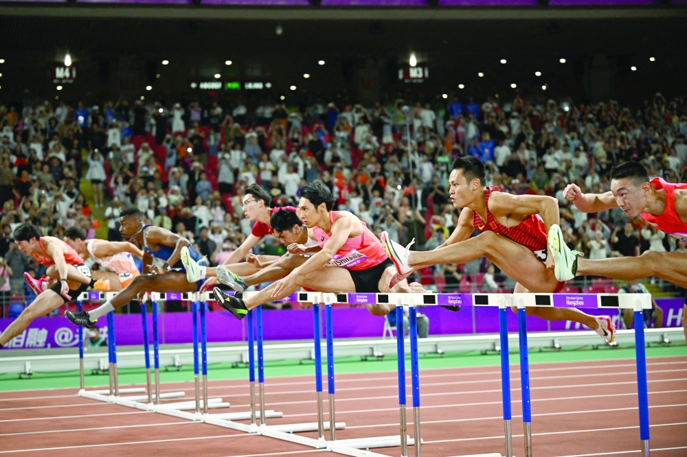 Athletes in action during the men's 110m hurdles final at Olympic Sports Centre Stadium, Hangzhou. -- Reuters