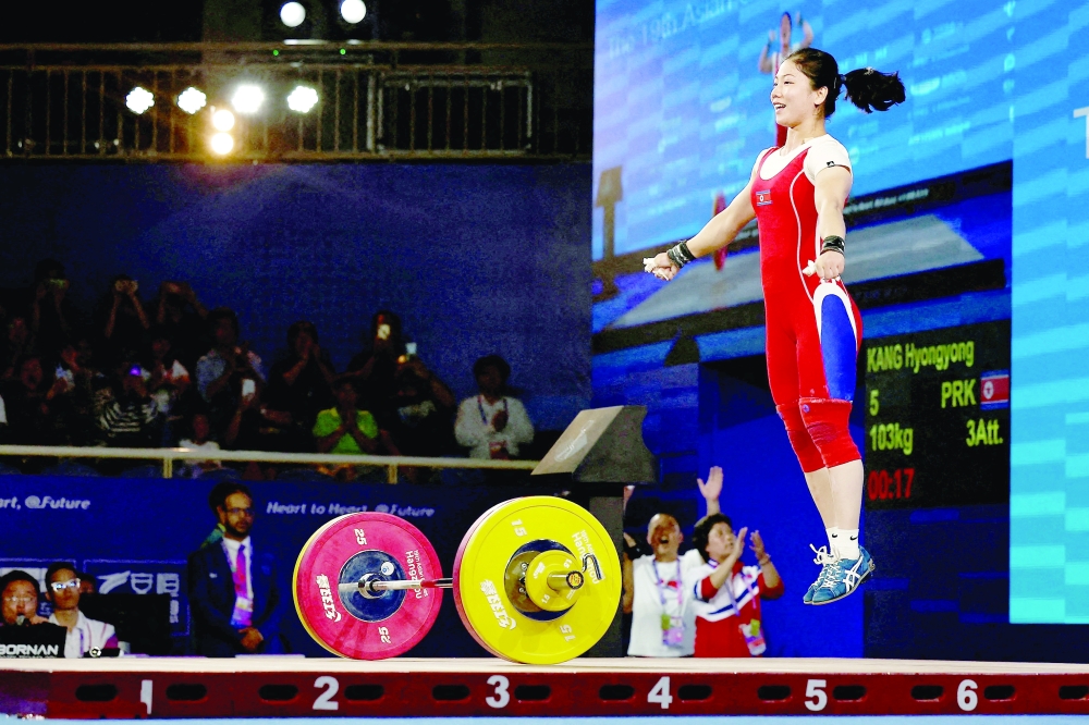North Korea's Hyongyong Kang reacts during the women's 55kg Group A weightlifting event. -- Reuters