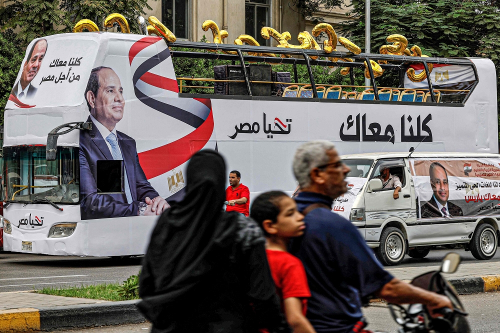 Supporters of Egypt's President Abdel Fattah al-Sisi wave national flags during a campaign rally ahead of the December elections outside the campus of the Cairo University in Giza, the twin city of the Egyptian capital, on October 2, 2023.