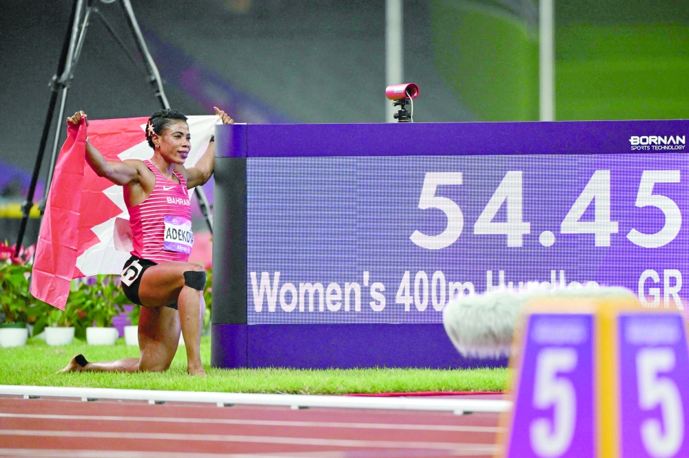 Bahrain's Kemi Adekoya poses next to her Asian Games new record after winning the women's 400m hurdles final athletics event during the 2022 Asian Games in Hangzhou. —AFP