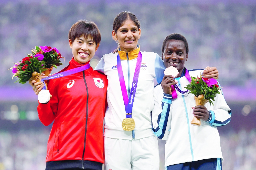 Women's 5000m gold medallist India's Parul Chaudhary stands with silver medallist Japan's Ririka Hironaka and bronze medallist Kazakhstan's Caroline Chepkoech Kipkirui during the medal ceremony after the final. -- Reuters
