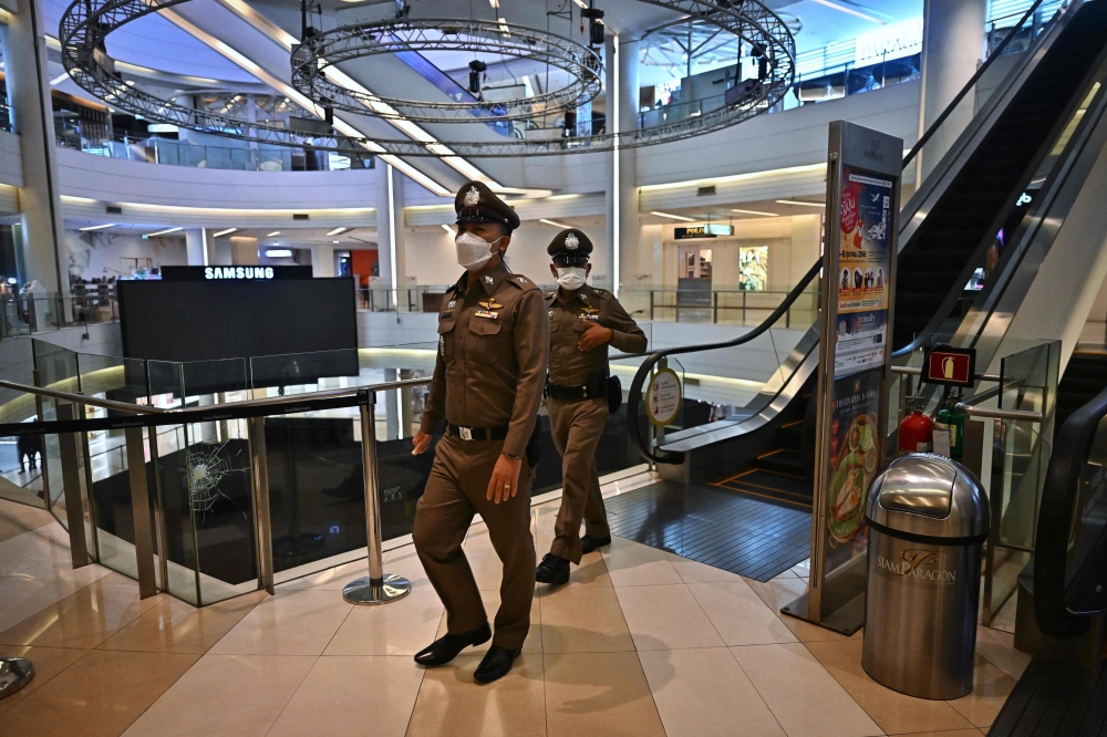 Thai police patrol inside the Siam Paragon shopping mall before opening in Bangkok on October 4, 2023