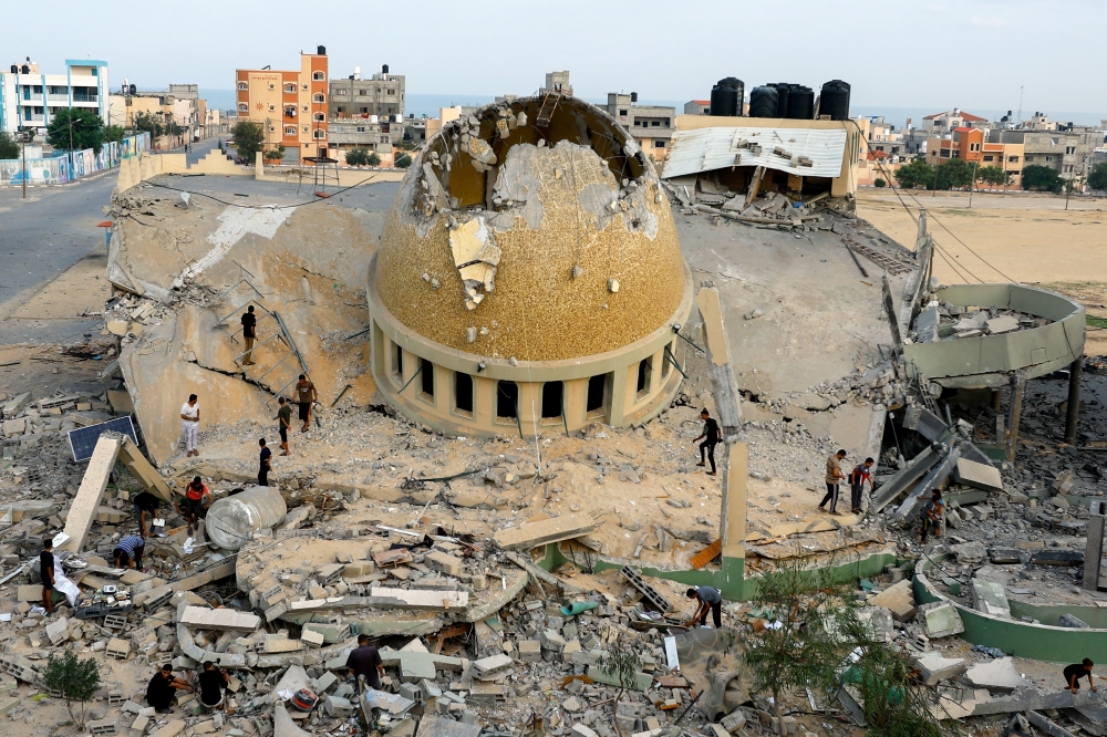 Palestinians inspect a mosque destroyed in Israeli strikes in Khan Younis, in the southern Gaza Strip, October 8, 2023. REUTERS/Ibraheem Abu Mustafa