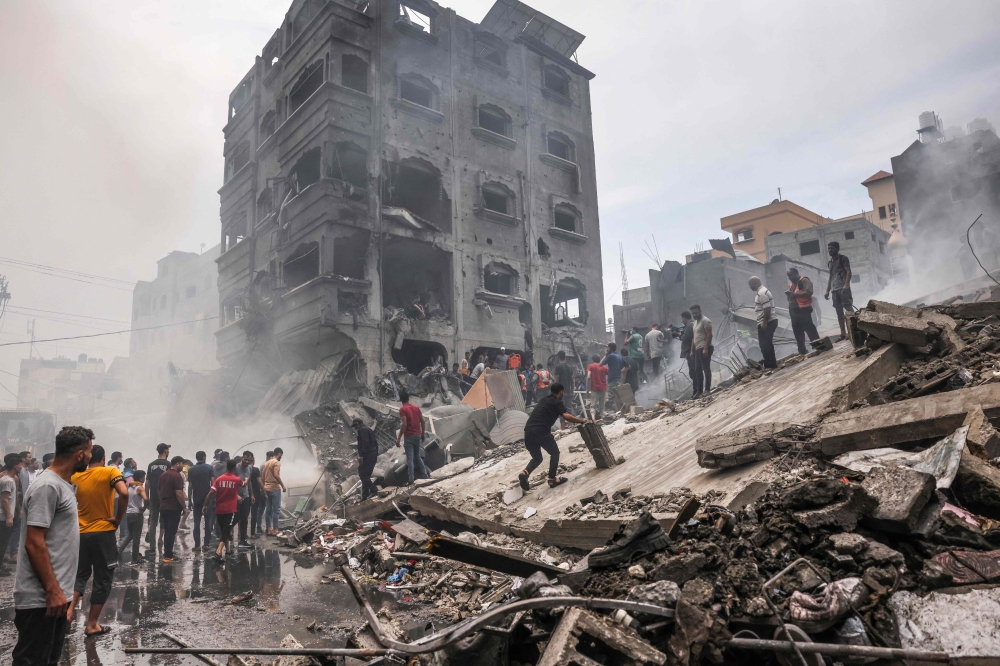 Palestinians search for survivors after an Israeli airstrike on buildings in the refugee camp of Jabalia in the Gaza Strip on October 9