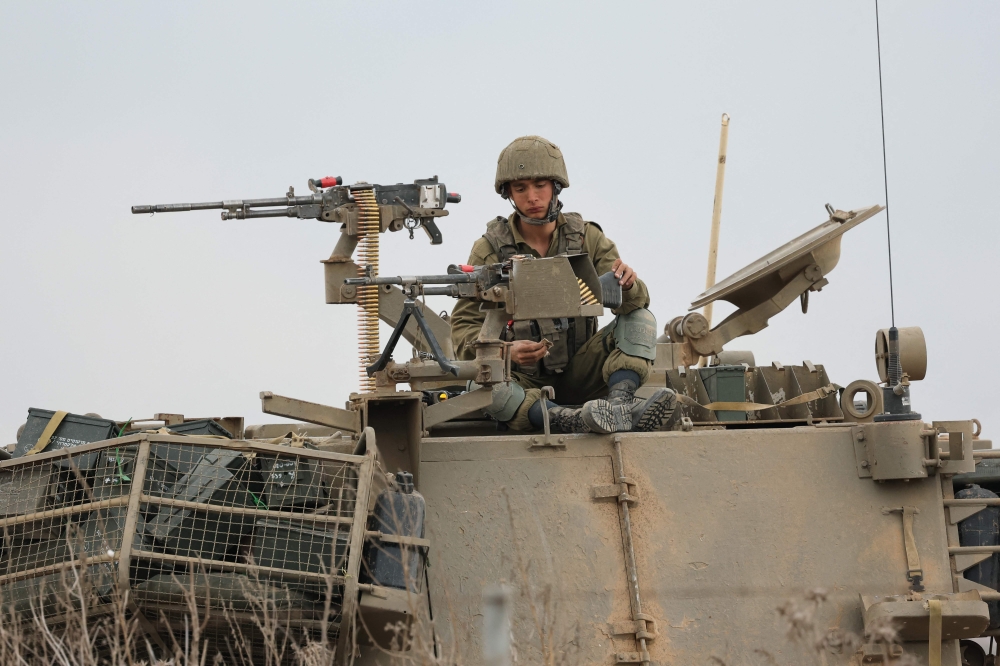 An Israeli soldier is positioned with troops at the border with Gaza in southern Israel on October 9, 2023. 