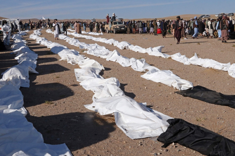 Afghan mourners prepare to offer mass funeral prayers for the people killed in a series of earthquakes in Zendeh Jan district 