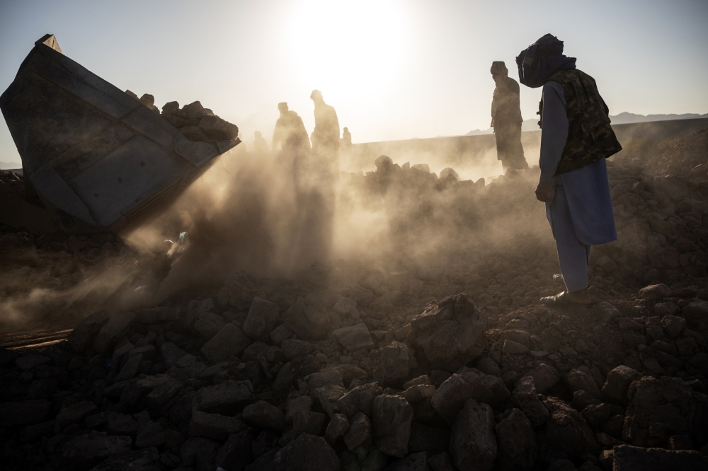 Local residents use a front loader to dig through the rubble of homes in the earthquake-ravaged village of Nayeb Rafi, in Herat Province, Afghanistan, on Tuesday, Oct. 10, 2023.  (Victor J. Blue/The New York Times)