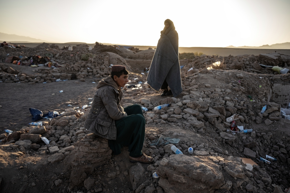 Local residents survey the destruction in the earthquake-ravaged village of Nayeb Rafi, in Herat Province, Afghanistan, on Tuesday, Oct. 10, 2023. He lost eight relatives in the collapse of the home. (Victor J. Blue/The New York Times)
