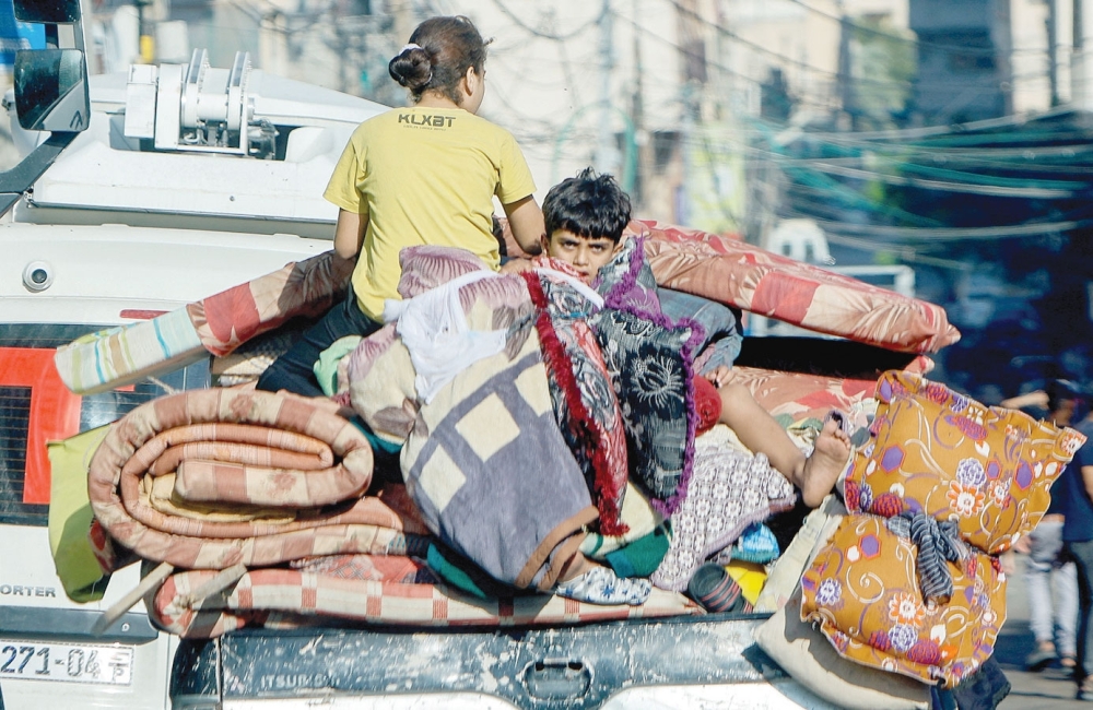 Palestinians flee their homes amid Israeli strikes, amid the ongoing conflict between Israel and Hamas in Gaza City on Friday. — Reuters