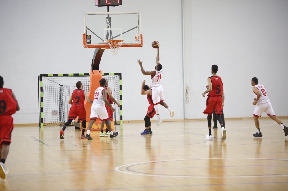 Oman Club player trying to score a basket