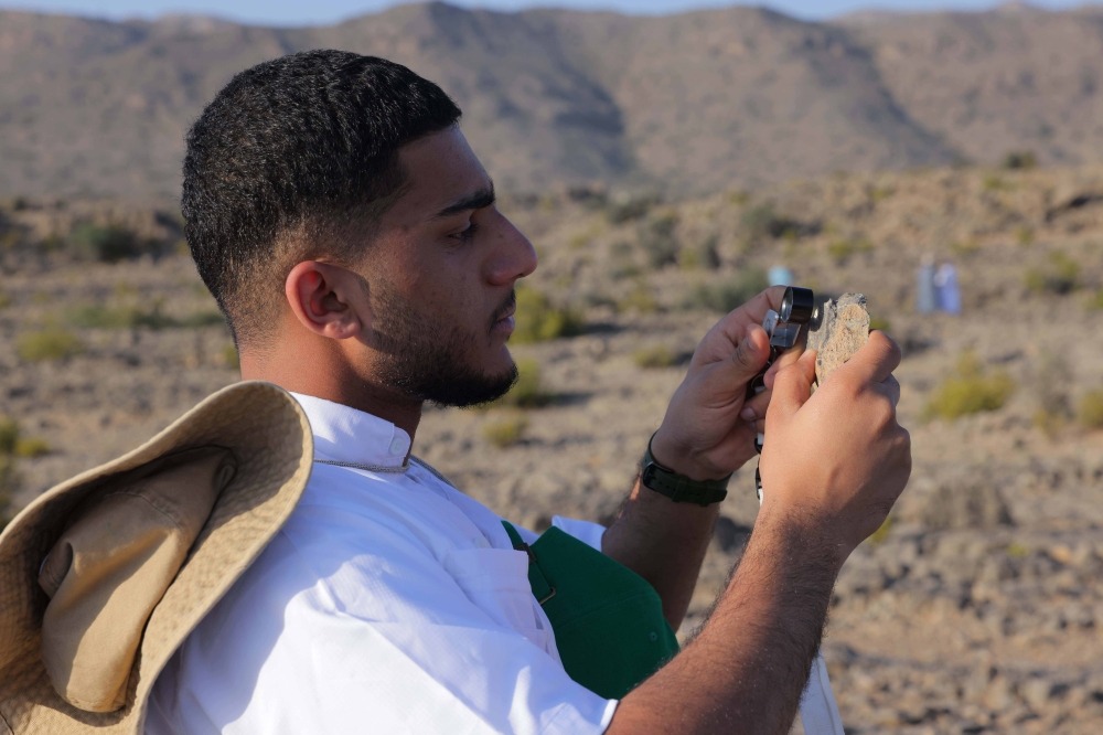 A student examines rock in Al Jabal Al Akhdar.