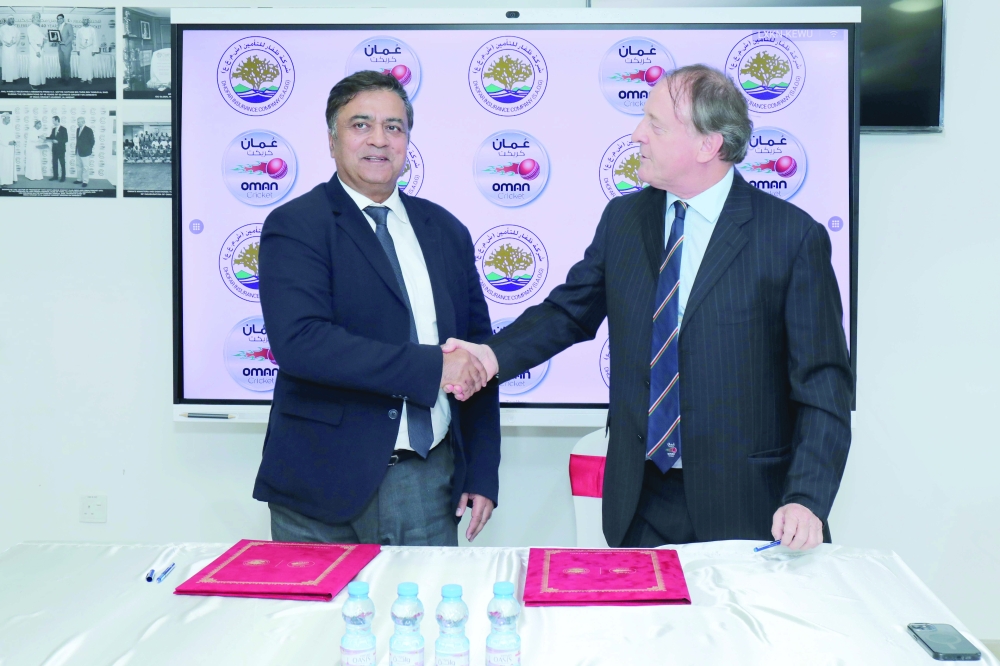 Sunil Kohli (left) shakes hands with Paul Sheridan after signing the agreement