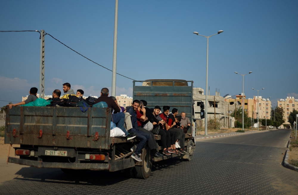 Palestinians flee their houses after Israel's call for more than 1 million civilians in northern Gaza to move south, in Khan Younis in the southern Gaza Strip, October 