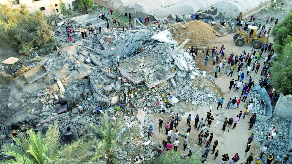 A view shows the remains of  Palestinian houses destroyed in Israeli strikes in the central Gaza Strip on Monday. - Reuters