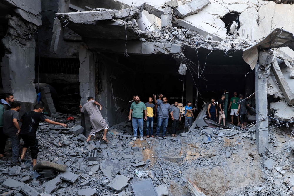  Palestinians civil look for survivors in the rubble of a building hit during Israeli bombardment in Khan Yunis